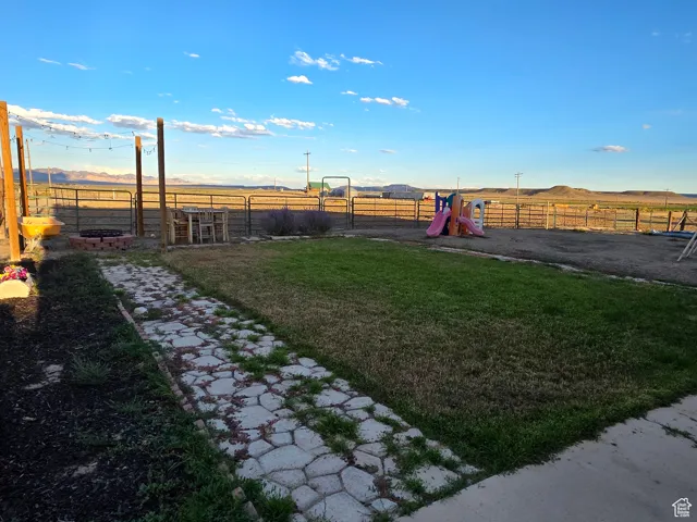 View of yard with a rural view, a mountain view, and a playground