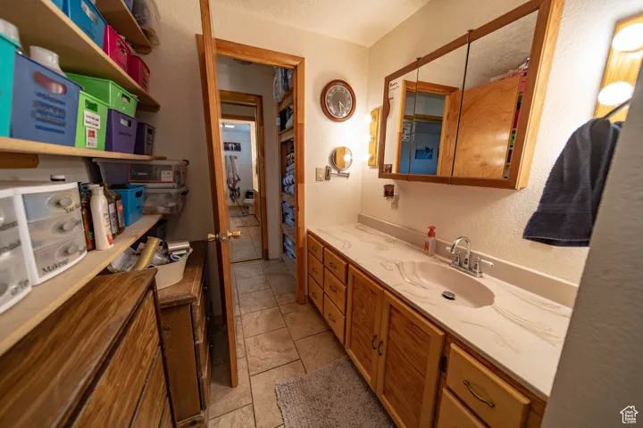 Bathroom featuring a textured wall, vanity, and a textured ceiling