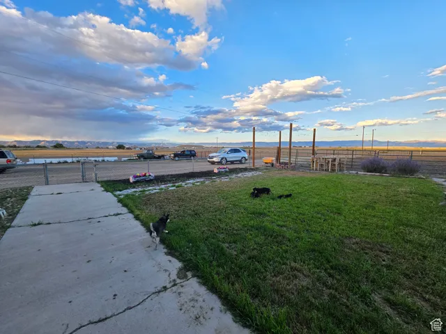 Yard at dusk featuring a water and mountain view