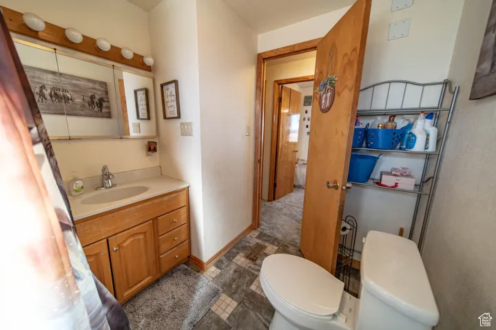Half bathroom with vanity and dark tile patterned flooring