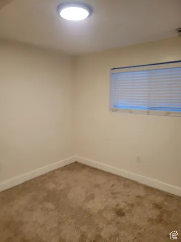Carpeted empty room with baseboards