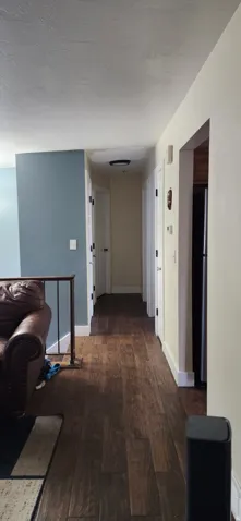 Hallway featuring dark wood finished floors and a textured ceiling
