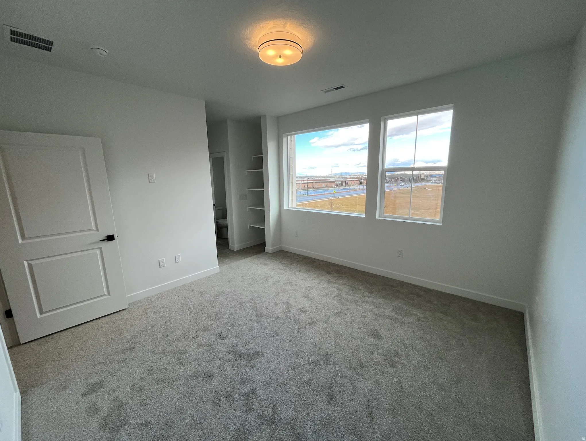 Unfurnished bedroom featuring light colored carpet and baseboards