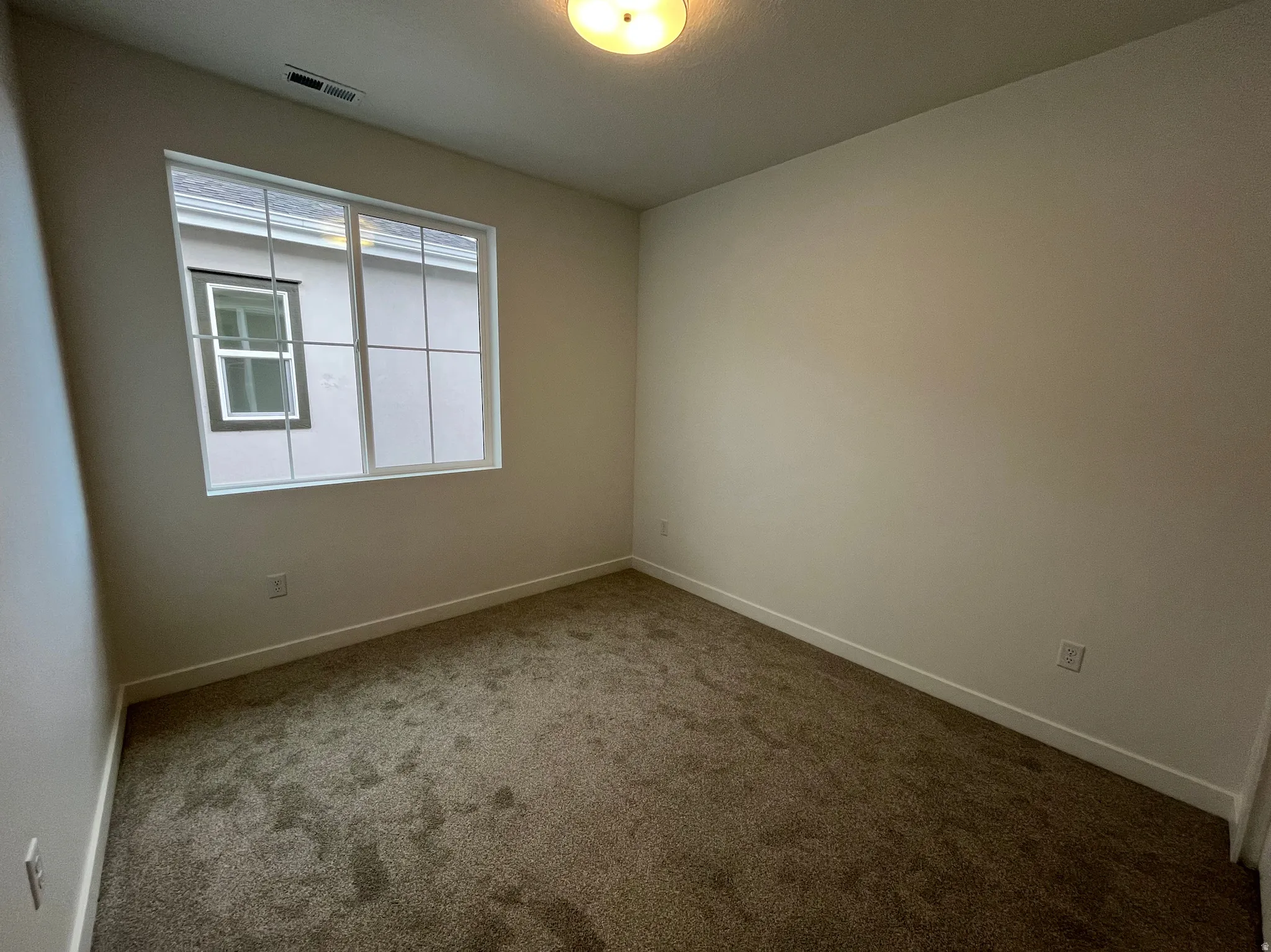 Empty room with carpet and baseboards