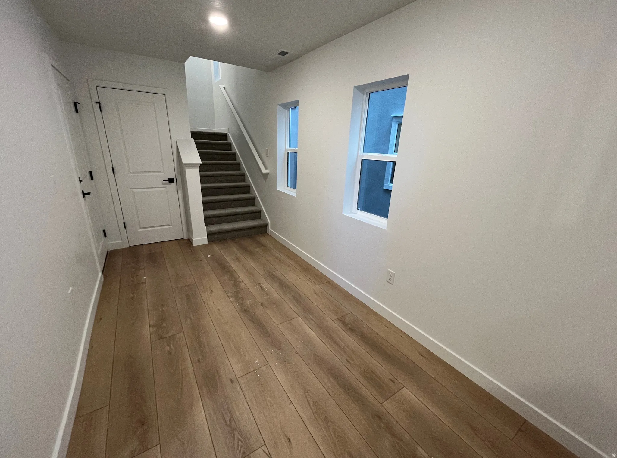 Corridor featuring stairs and hardwood / wood-style flooring