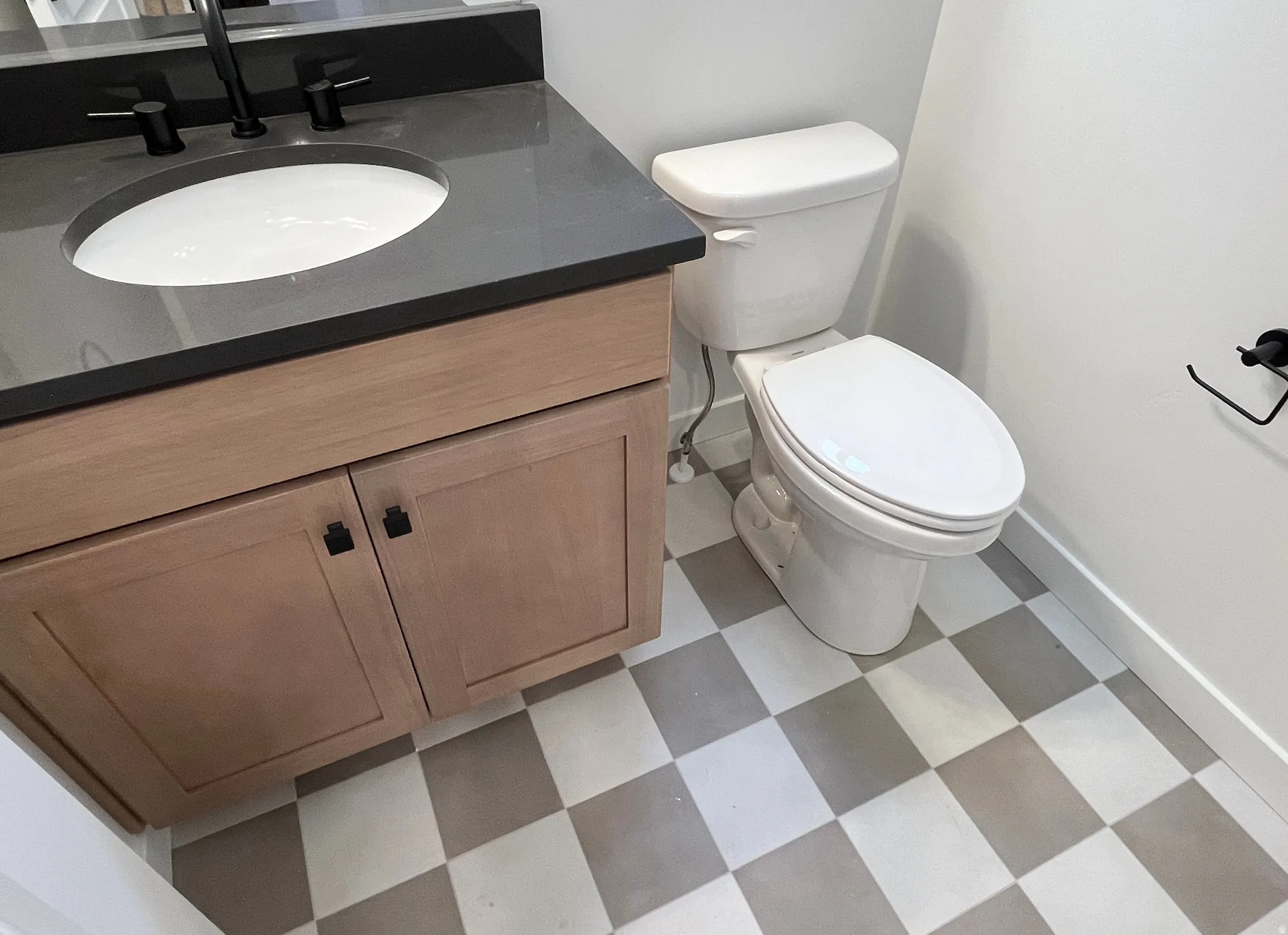 Half bathroom with vanity and light flooring