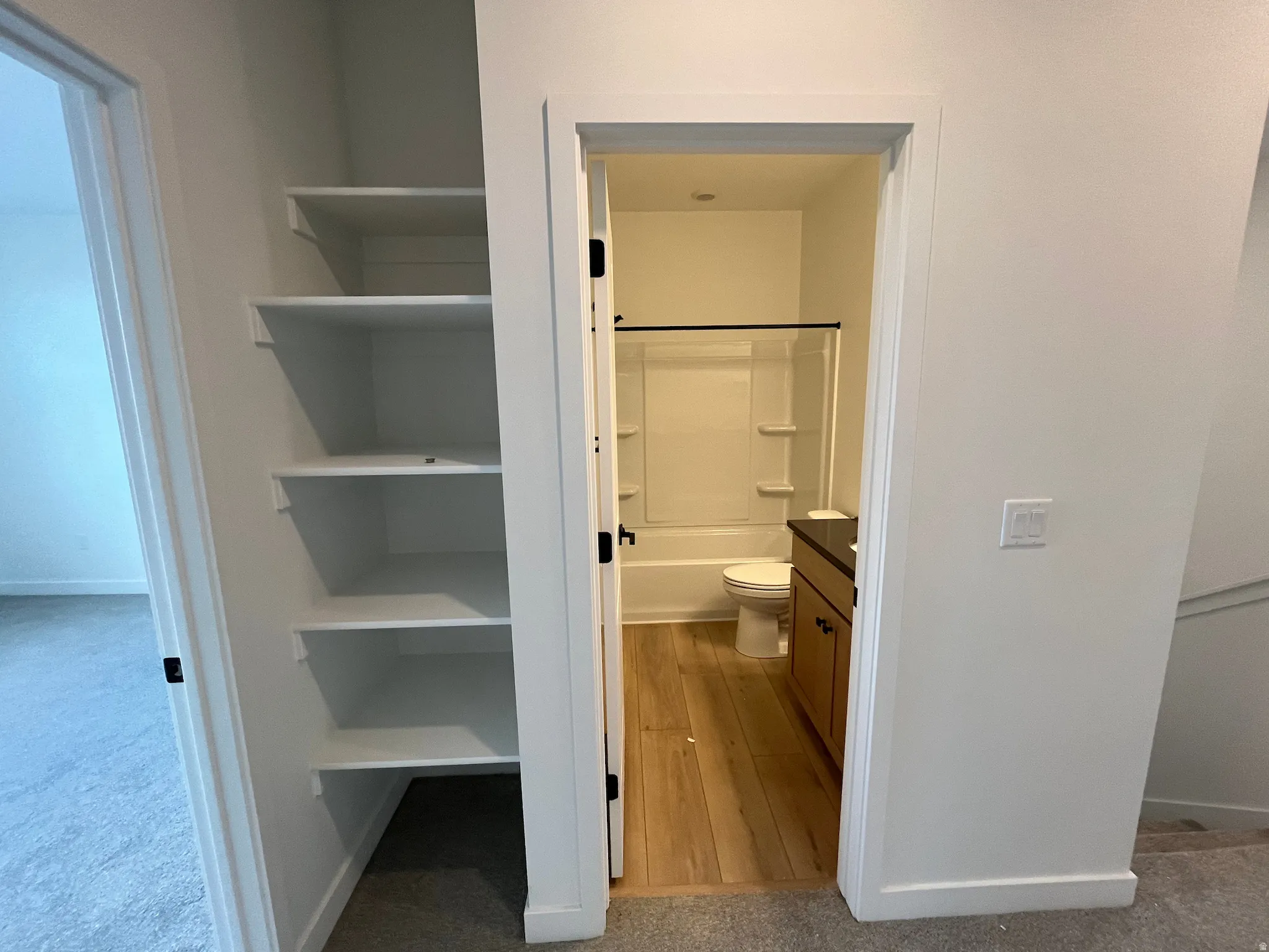 Bathroom featuring vanity, washtub / shower combination, and light colored carpet