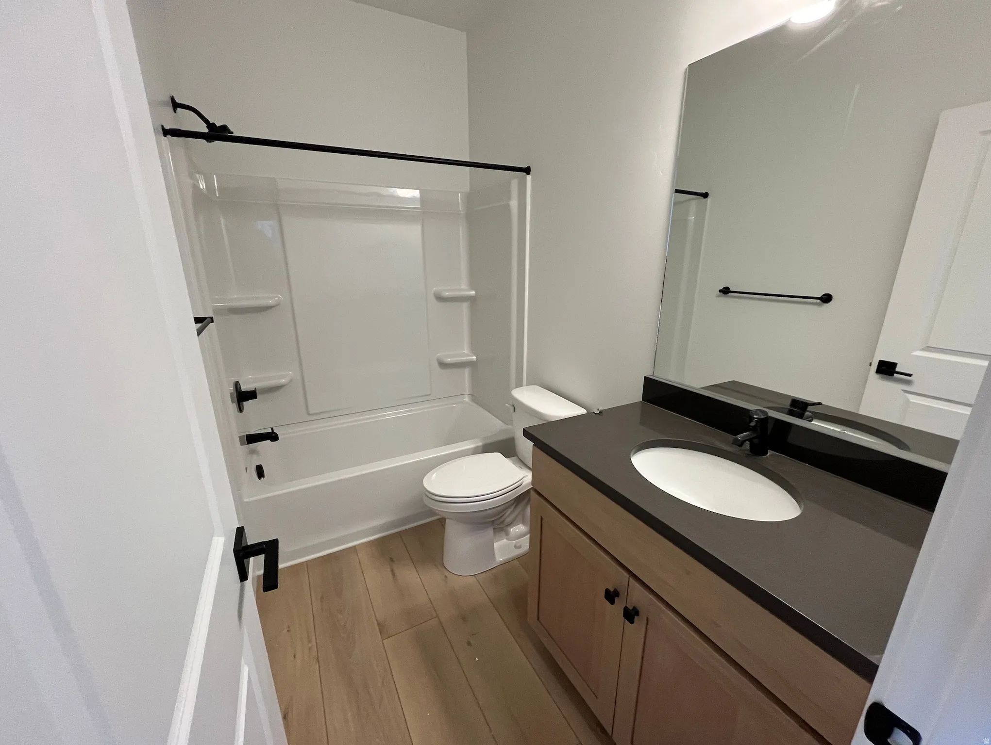 Full bath with vanity, bathtub / shower combination, and light wood-type flooring