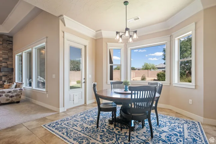 Dining area with a chandelier, crown molding, and light tile patterned floors