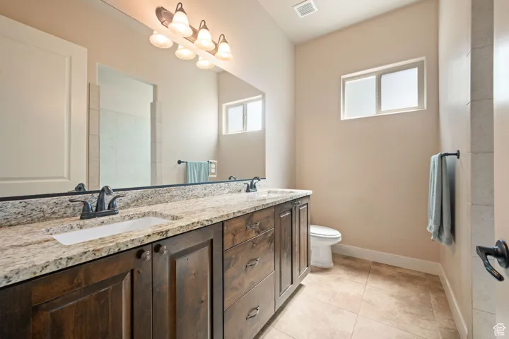 Bathroom featuring double vanity and light tile patterned floors