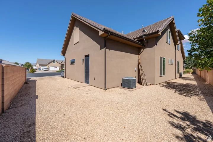 Back of house featuring stucco siding and a tile roof