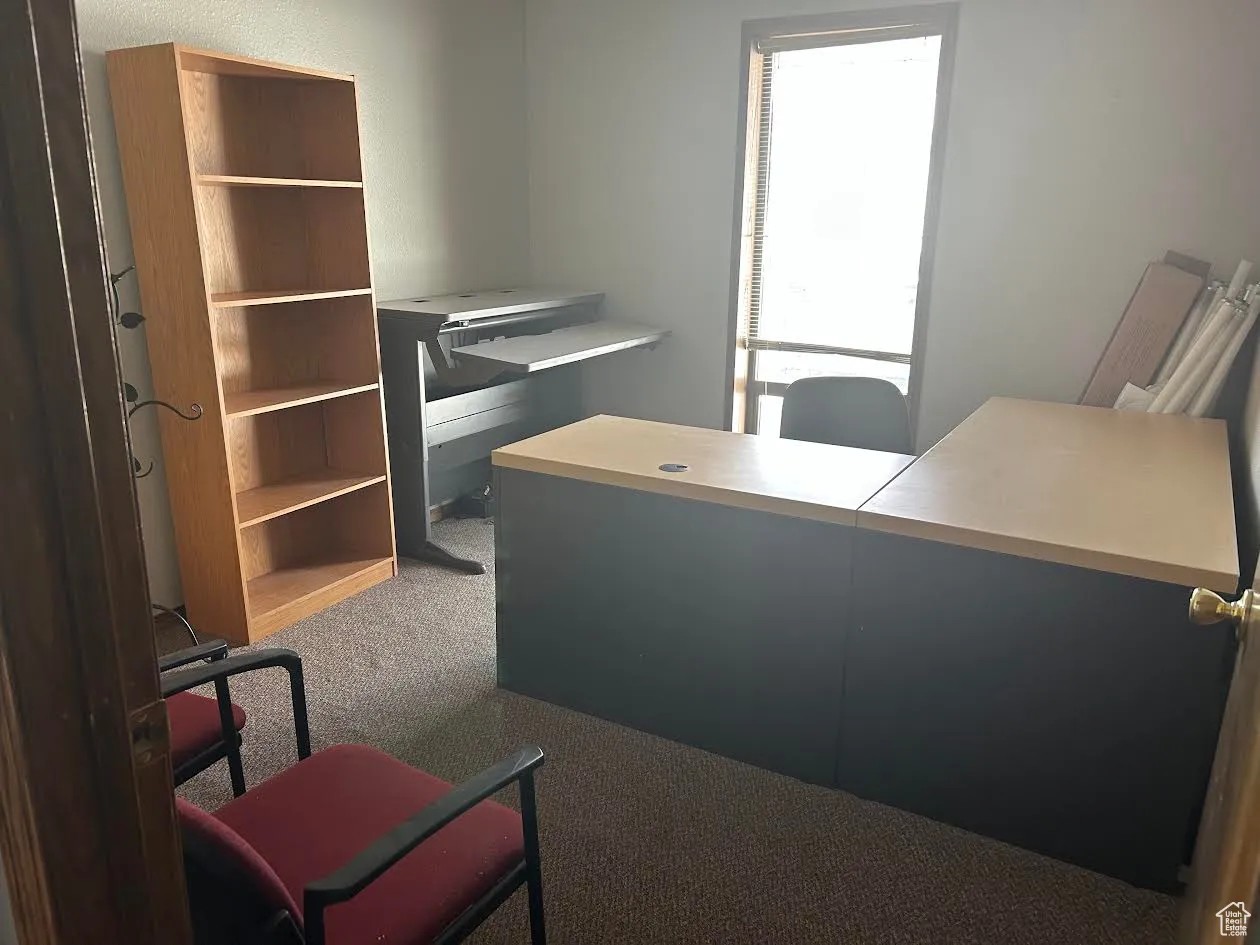 Home office featuring dark colored carpet