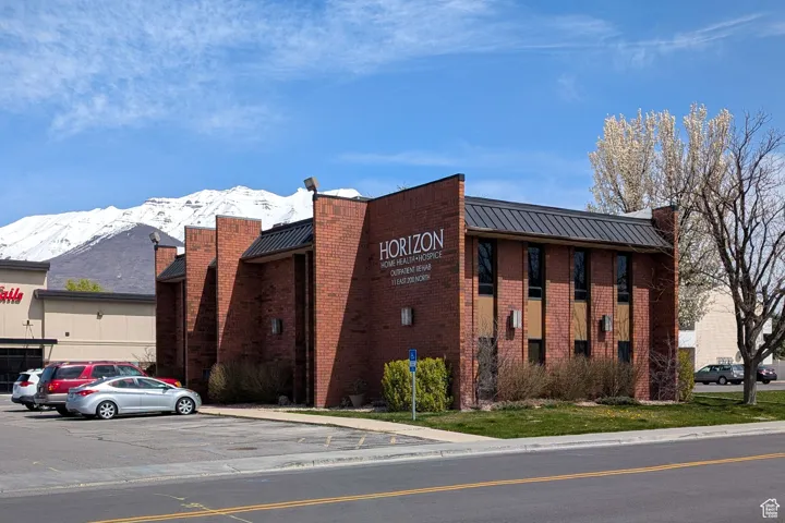 View of building exterior with a mountain view and uncovered parking