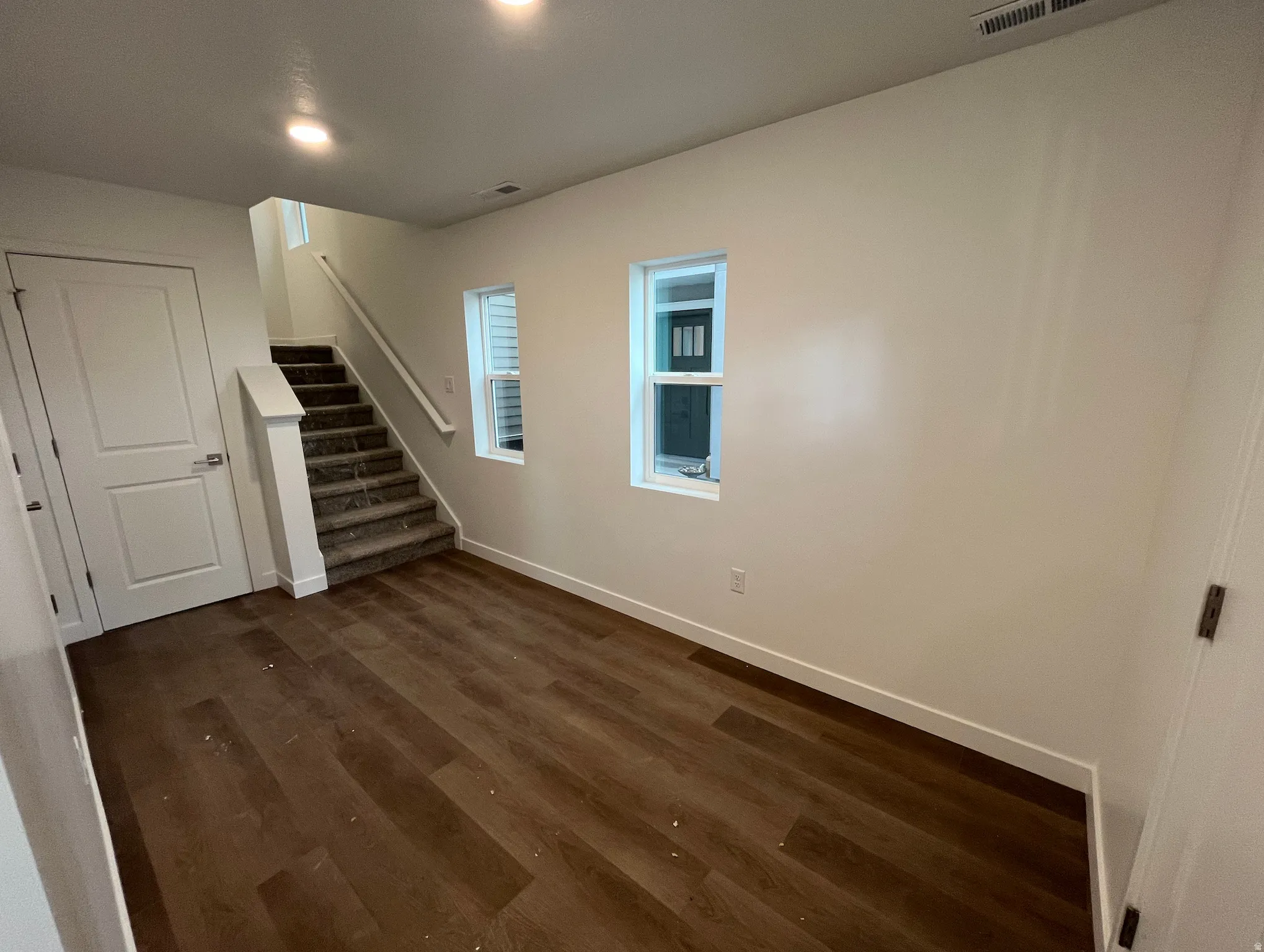Basement with dark wood-type flooring and stairway
