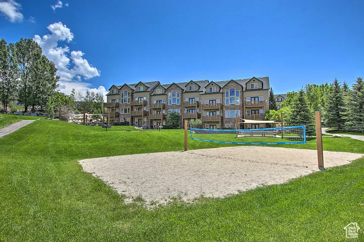 View of home's community featuring a yard and volleyball court