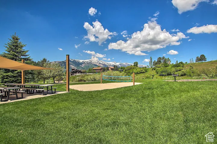 View of property's community featuring volleyball court and a lawn
