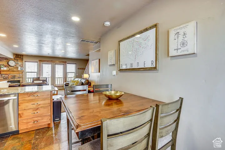 Dining room featuring recessed lighting, a textured ceiling, and a fireplace