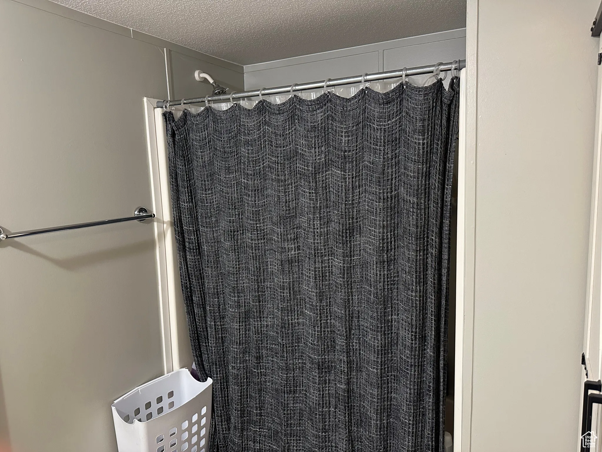 Bathroom featuring a textured ceiling and a shower with curtain