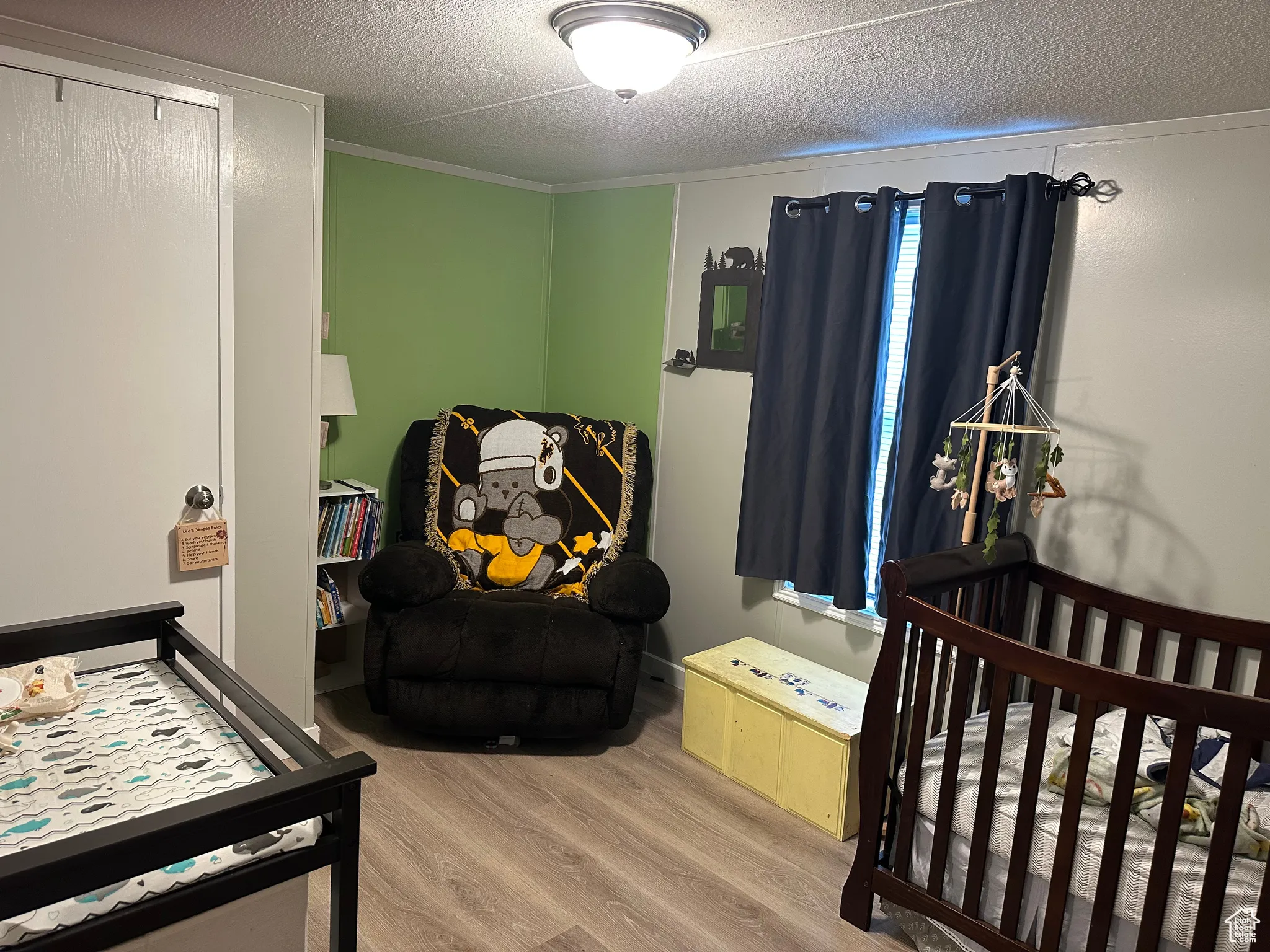 Bedroom with wood finished floors and a textured ceiling