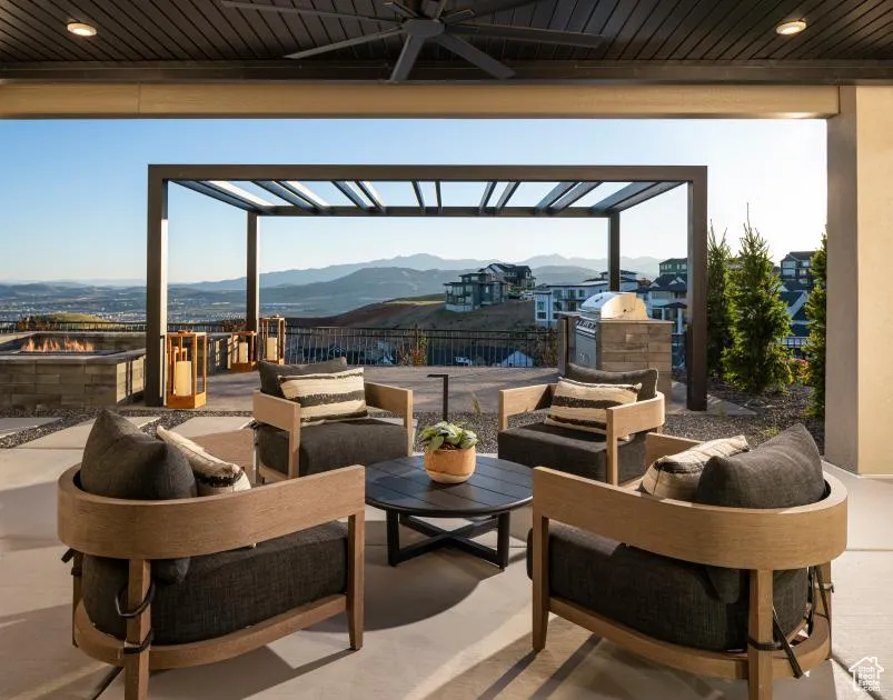 View of patio / terrace with a mountain view, a ceiling fan, exterior kitchen, an outdoor hangout area, and a pergola