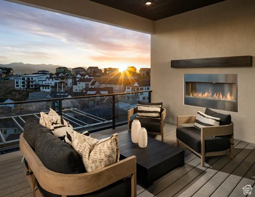 Balcony at dusk with an outdoor living space with a fireplace