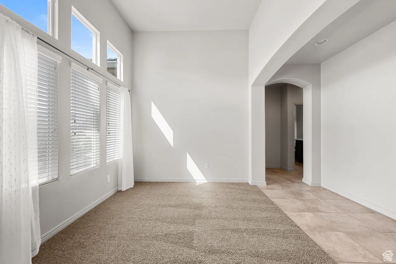 Empty room with arched walkways and light carpet