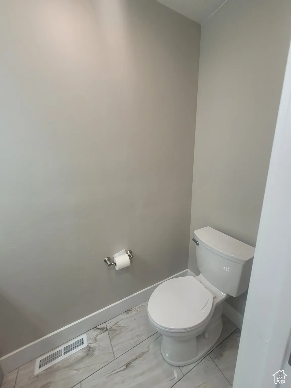 Bathroom with toilet and light marble finish flooring