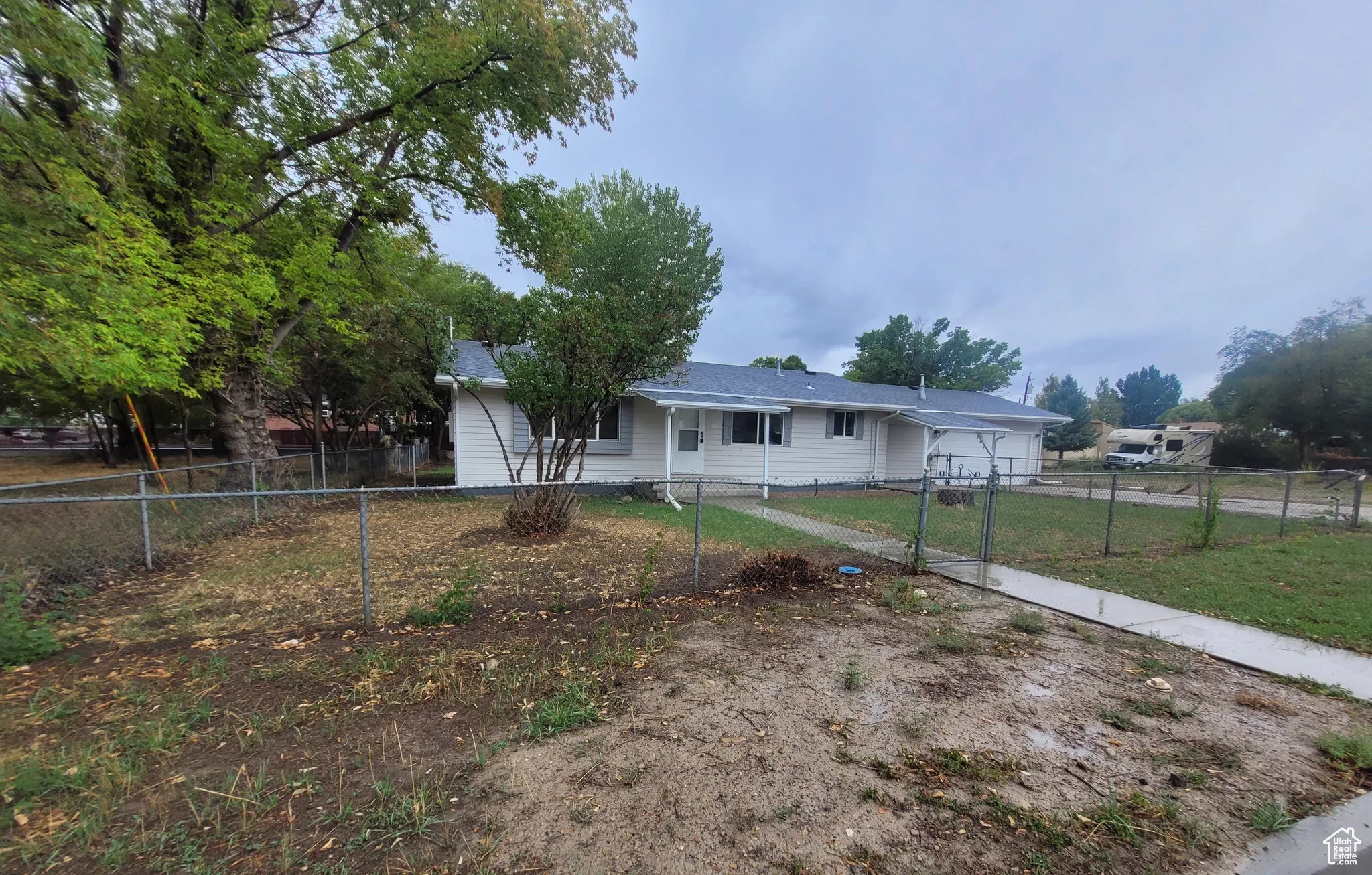Ranch-style house with a fenced front yard, an attached garage, and a gate