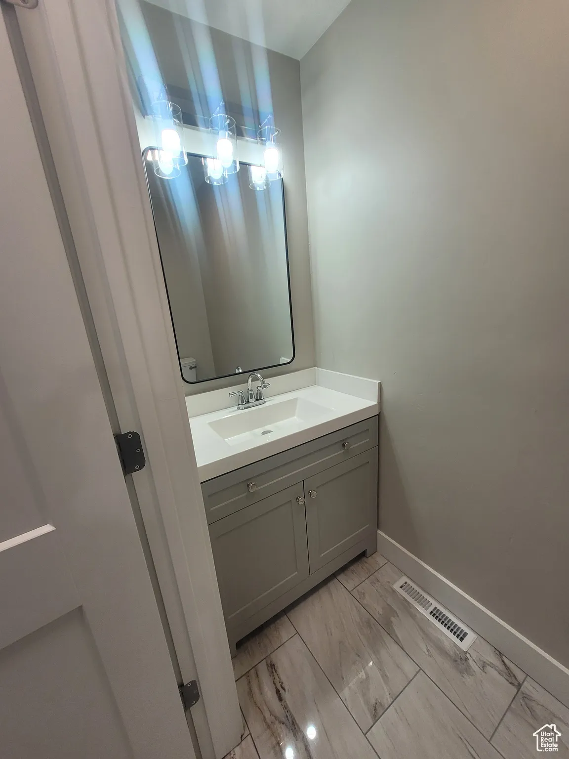 Bathroom featuring vanity and light marble finish floors