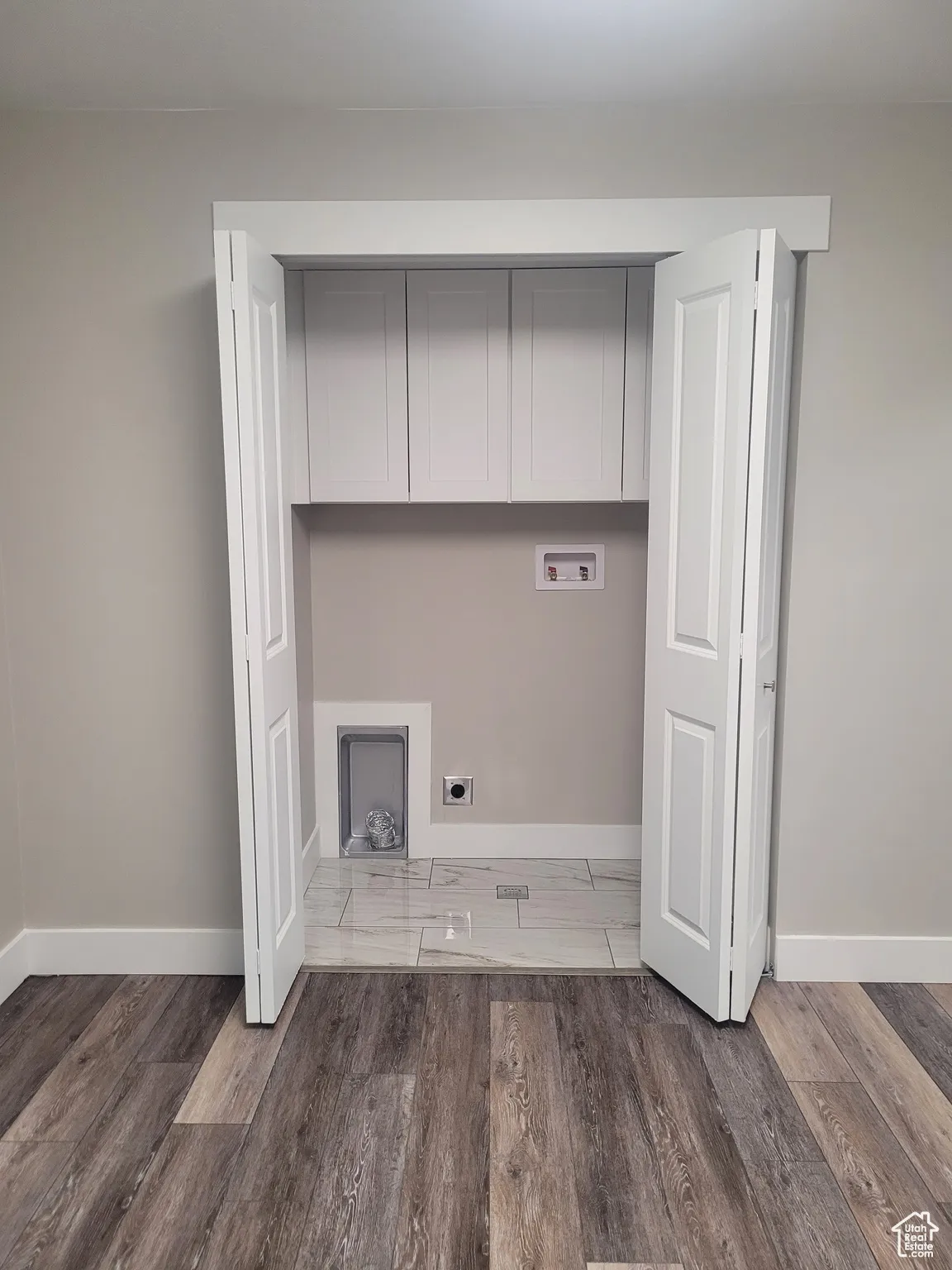 Laundry area with light wood-style flooring, hookup for a washing machine, and electric dryer hookup