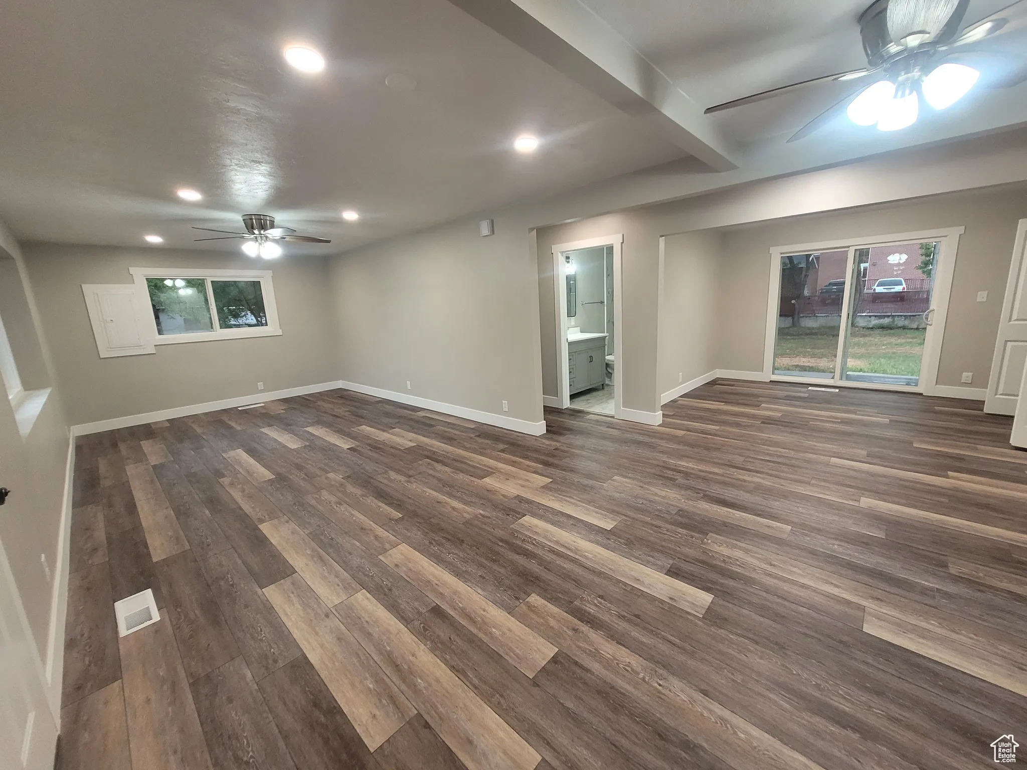 Empty room featuring a ceiling fan, dark wood-style flooring, recessed lighting, and beamed ceiling