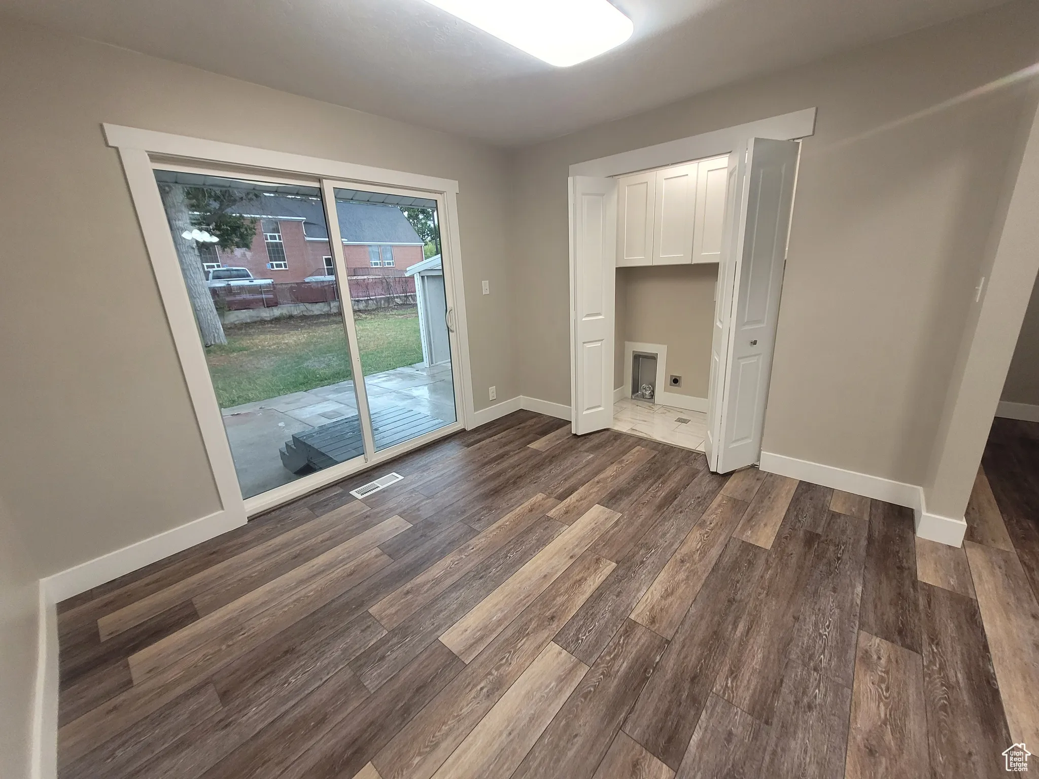 Unfurnished bedroom featuring a closet, access to outside, and dark wood finished floors