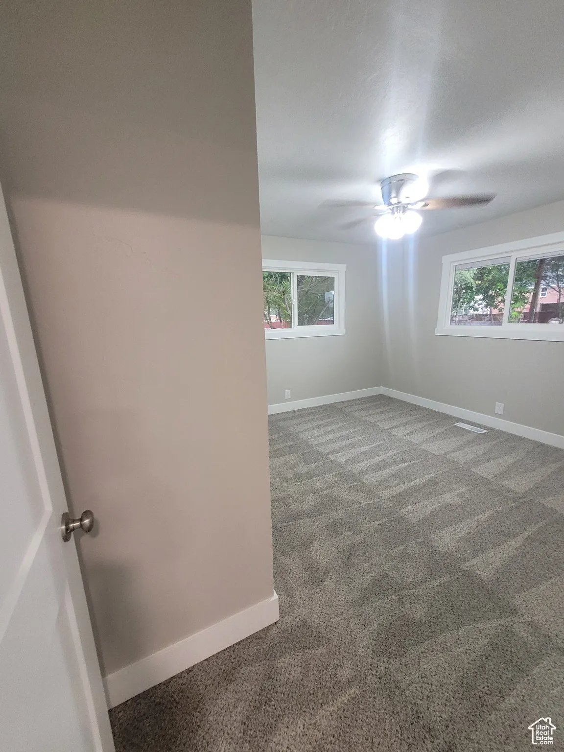 Spare room featuring carpet flooring and ceiling fan