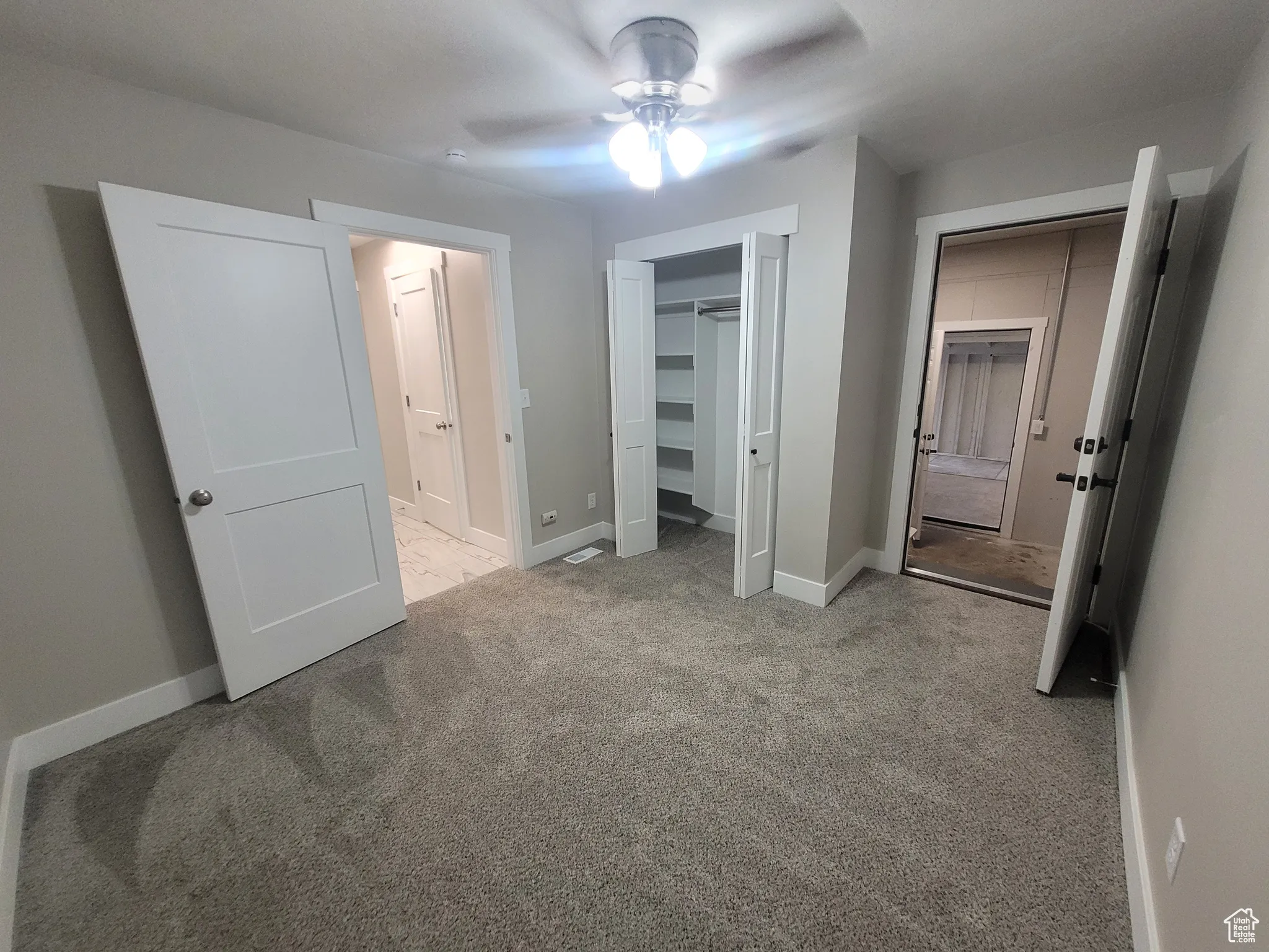 Unfurnished bedroom with light carpet, a closet, and ceiling fan