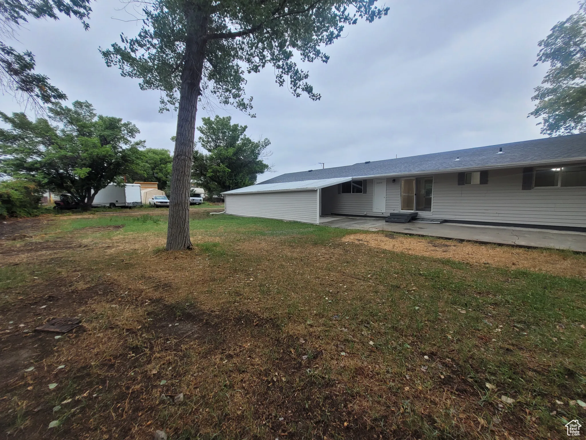 View of green lawn with a patio area