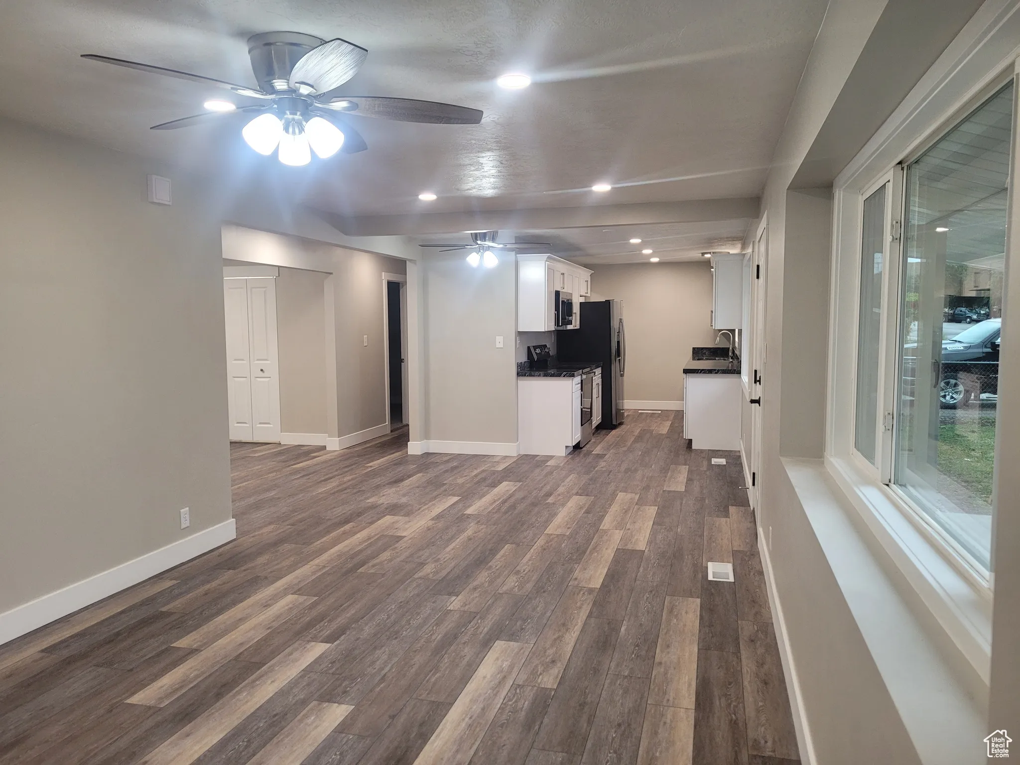 Unfurnished living room with recessed lighting, dark wood-style floors, and a ceiling fan