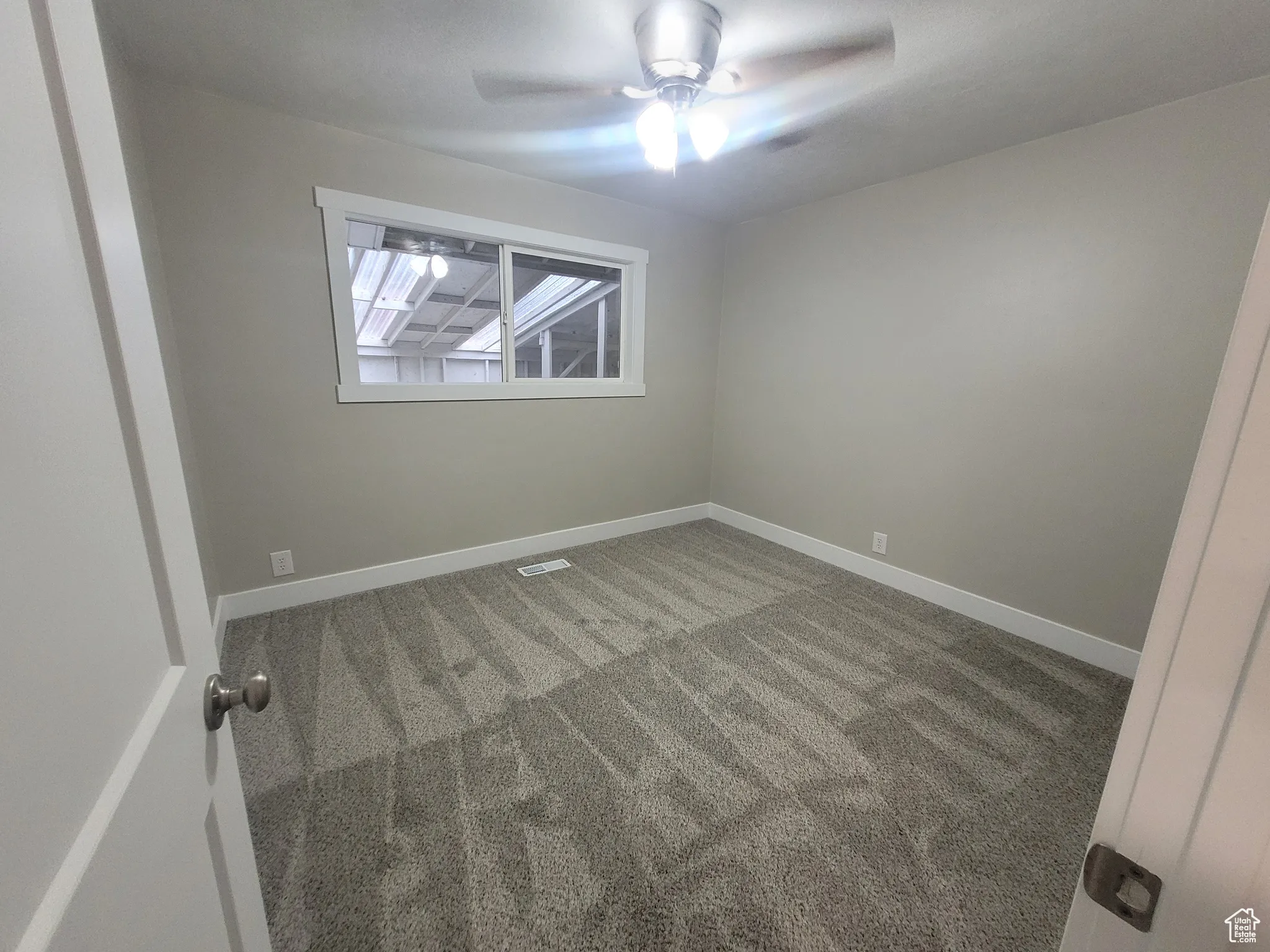 Spare room with carpet floors and ceiling fan