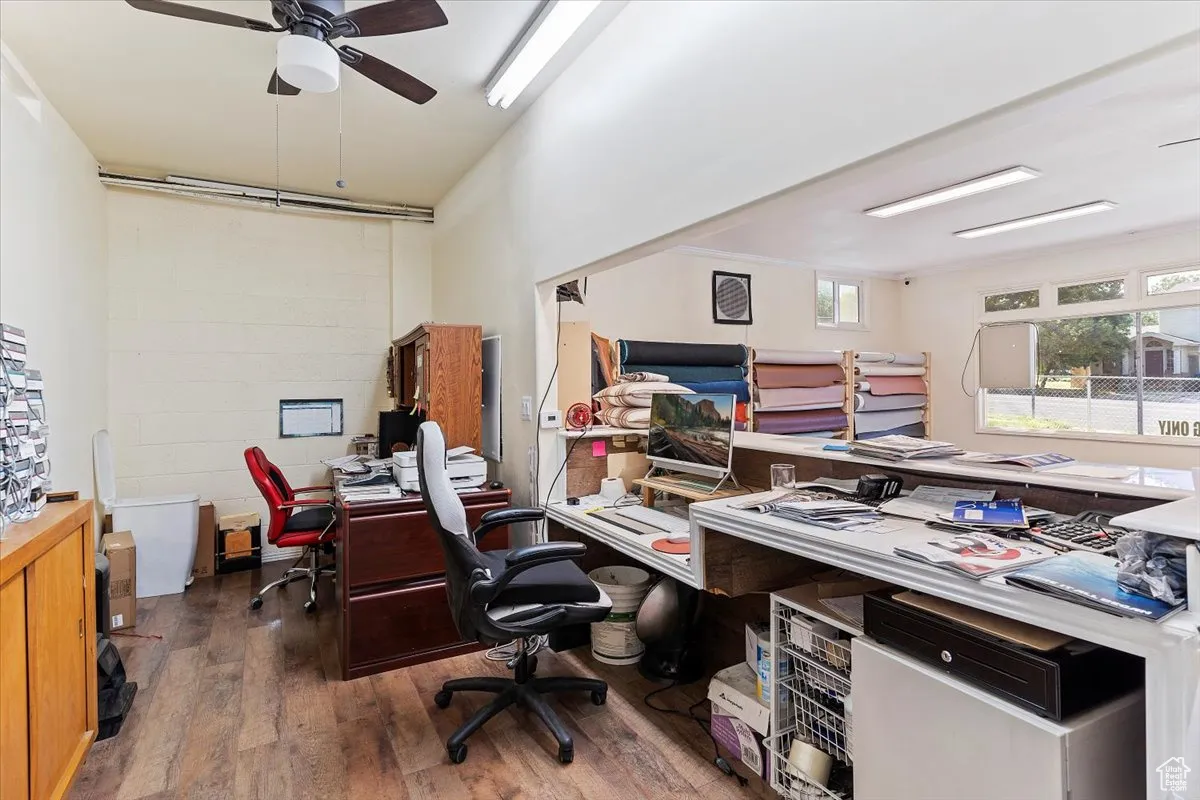 Office space with dark wood-type flooring and a ceiling fan