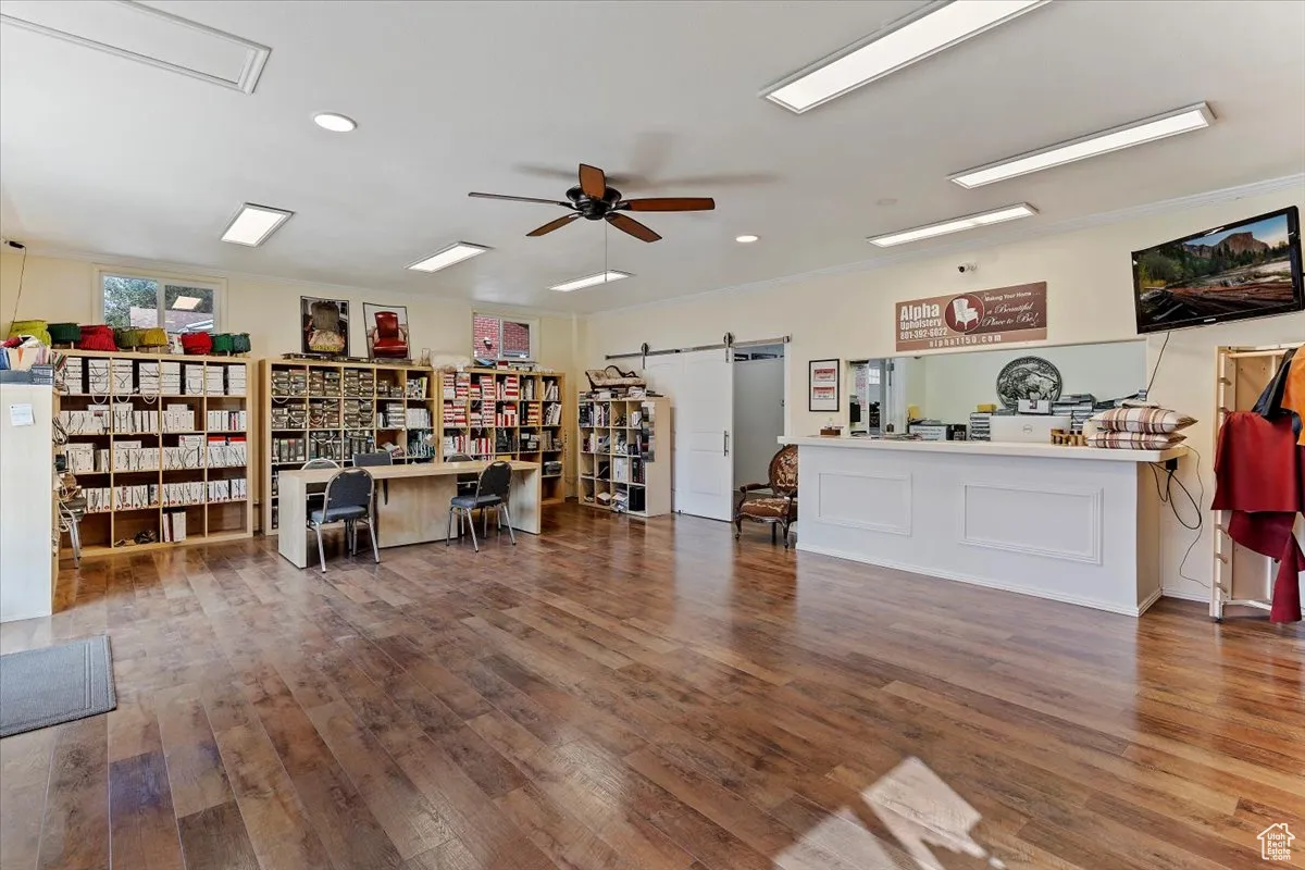 Miscellaneous room featuring a barn door, wood-type flooring, ceiling fan, and recessed lighting