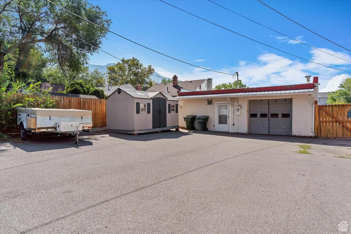 Single story home with a metal roof, an attached garage, stucco siding, and an outdoor structure