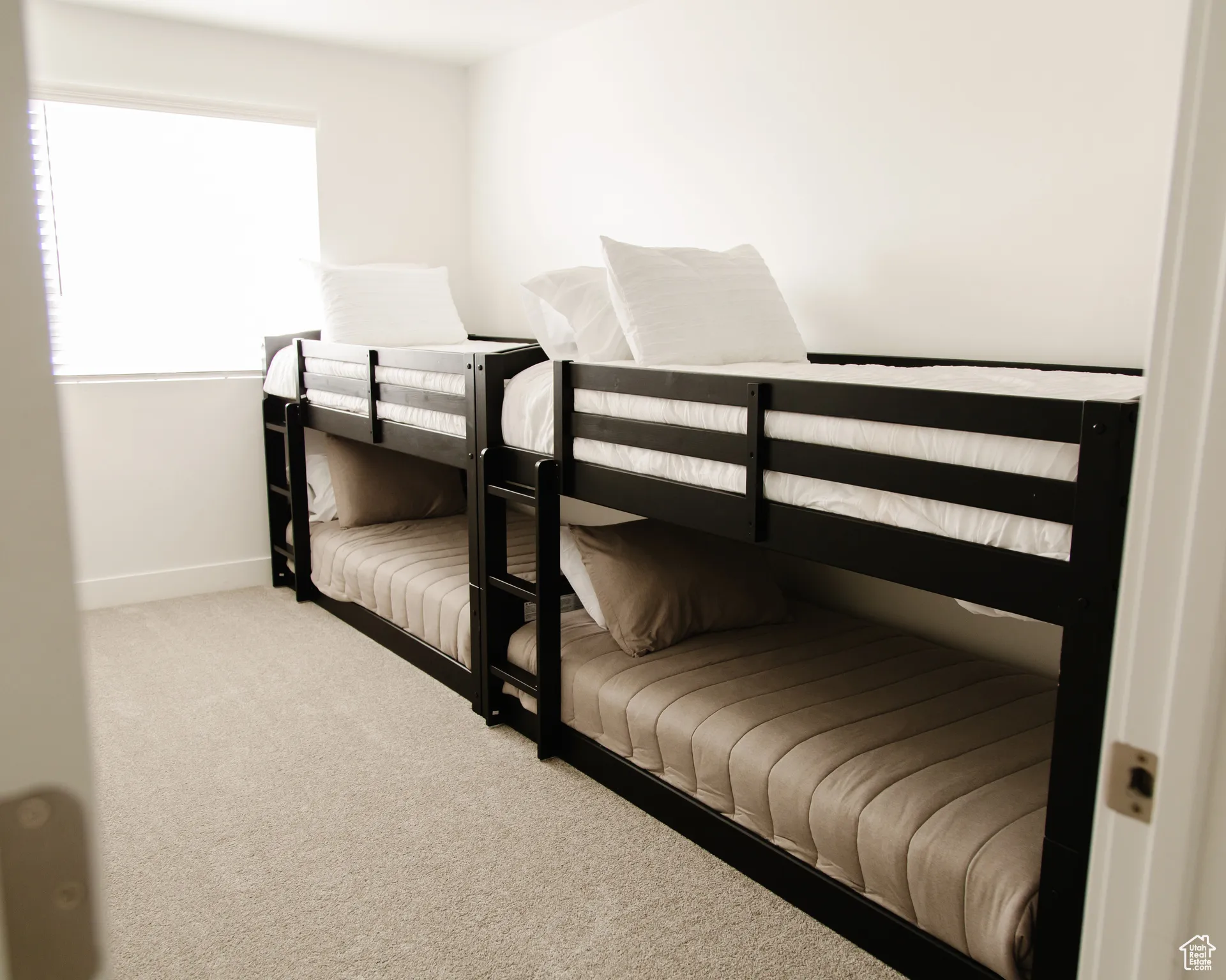 Bedroom featuring light carpet and baseboards