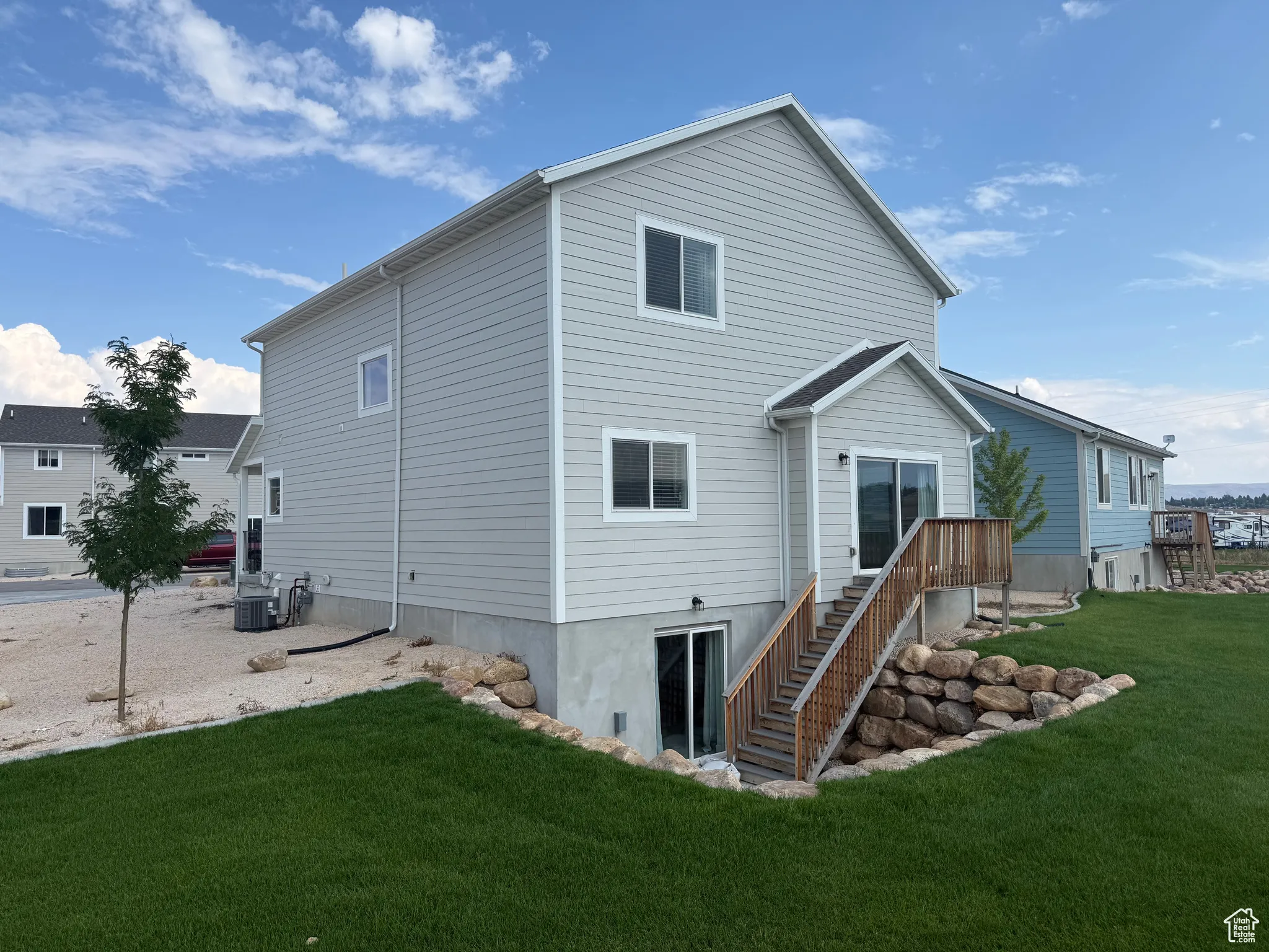 Back of property featuring a lawn and stairway