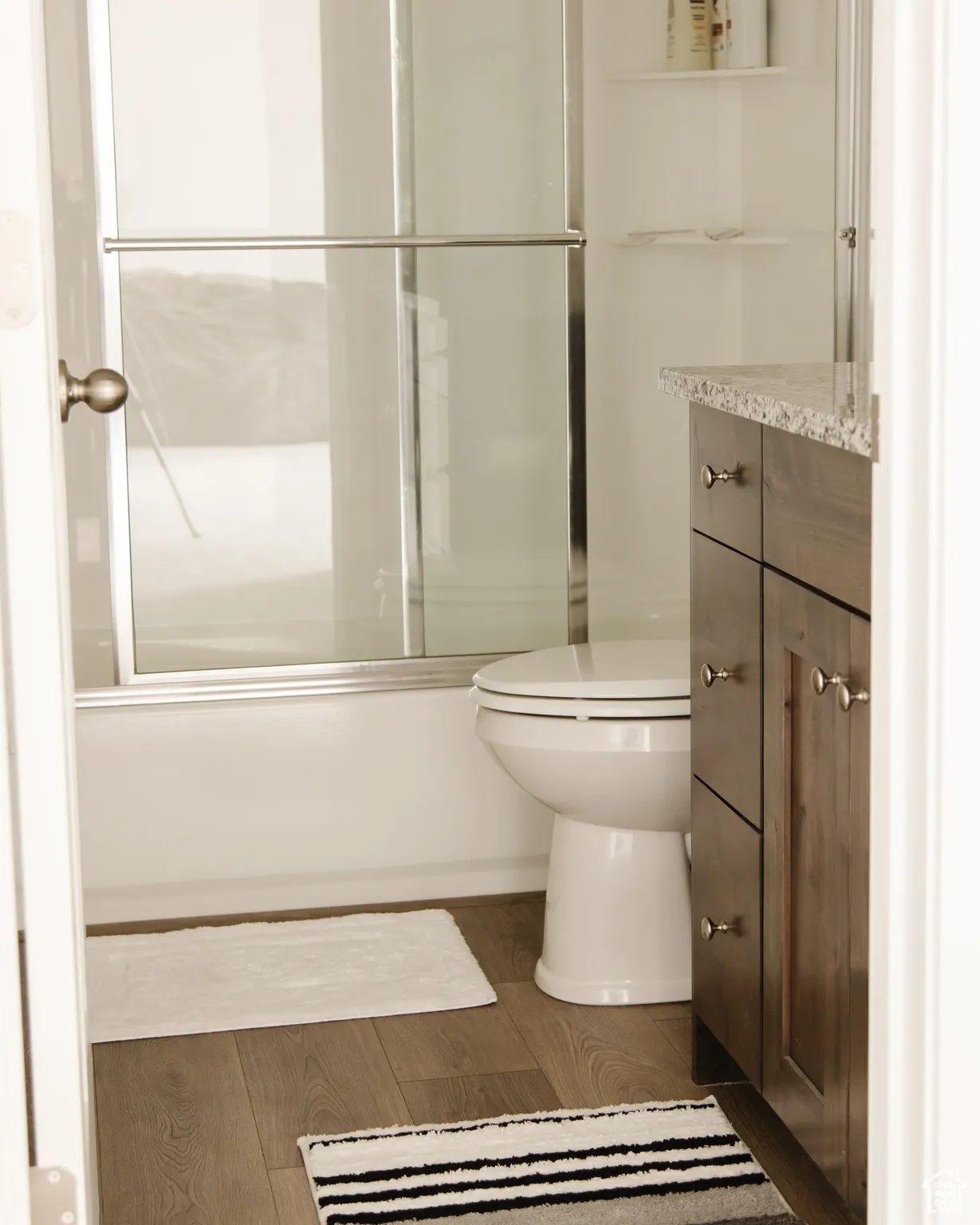 Full bath featuring vanity and shower / bath combination with glass door