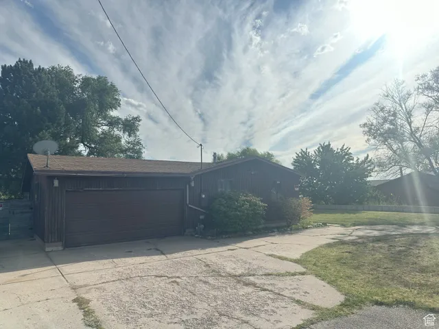 View of side of home featuring concrete driveway, a garage, and board and batten siding