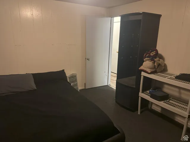 Bedroom with wooden walls and dark carpet
