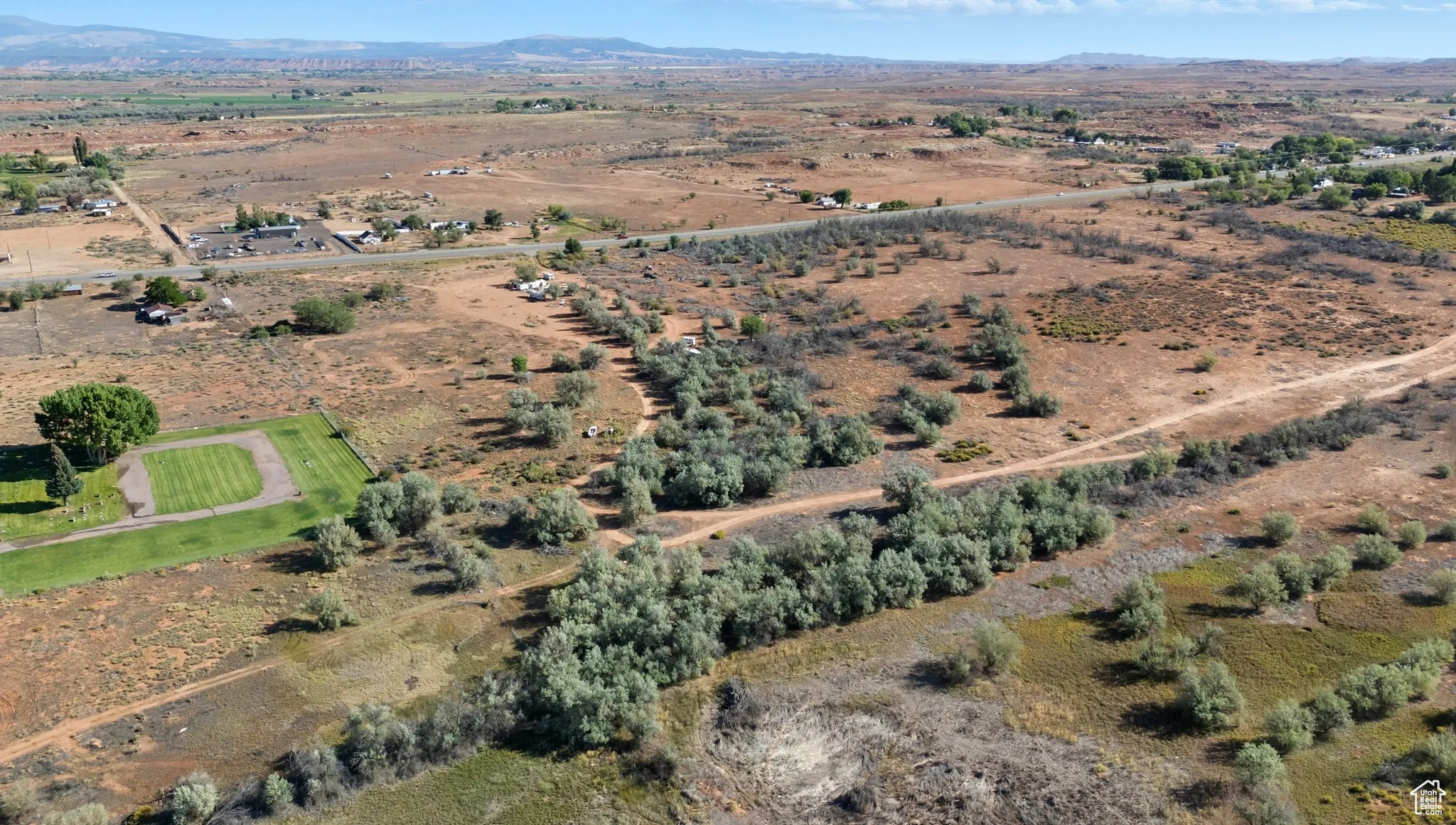 Aerial view of property and surrounding area featuring rural landscape and a mountain backdrop