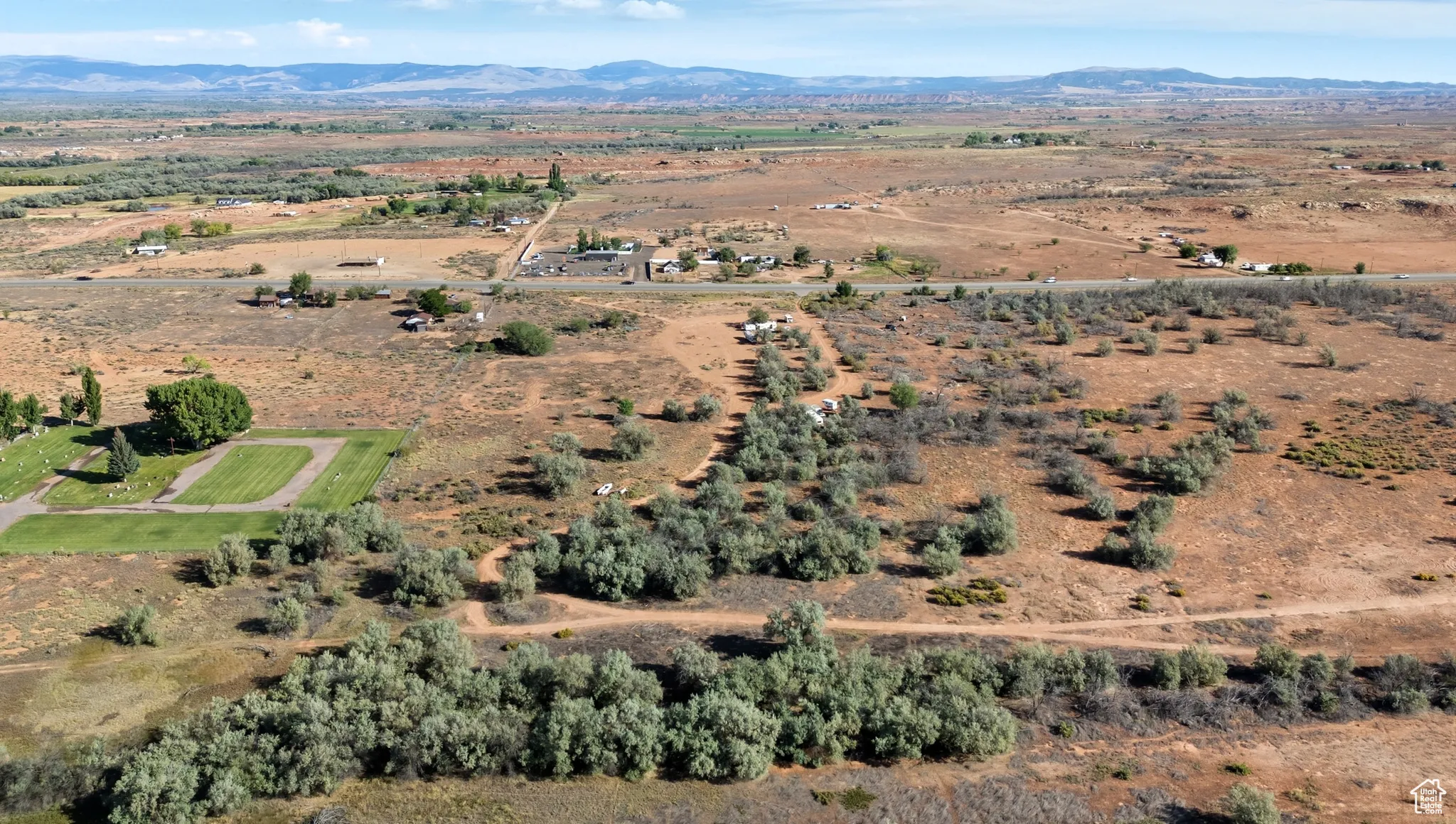 Aerial view of property and surrounding area with rural landscape and a mountainous background