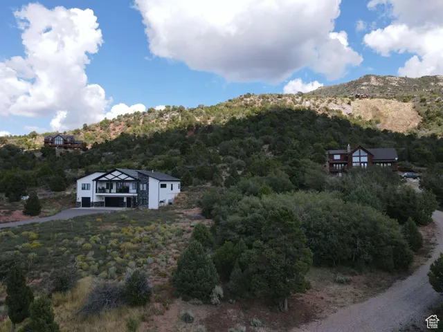 Aerial view of property and surrounding area with a heavily wooded area