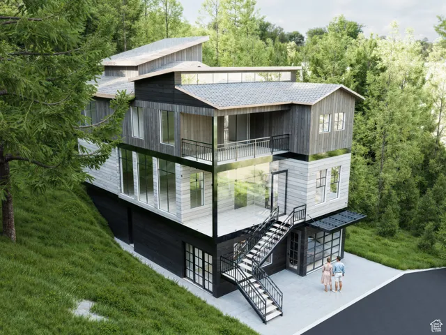 Back of property featuring a balcony, stairway, a patio, and a yard