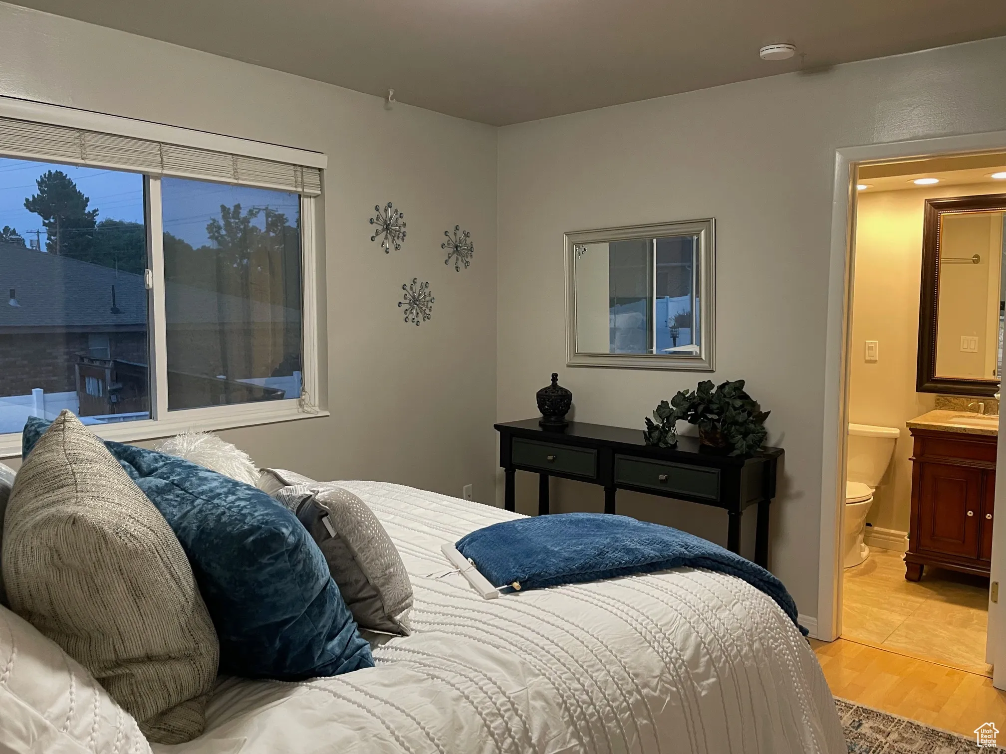 Bedroom featuring light wood finished floors and connected bathroom